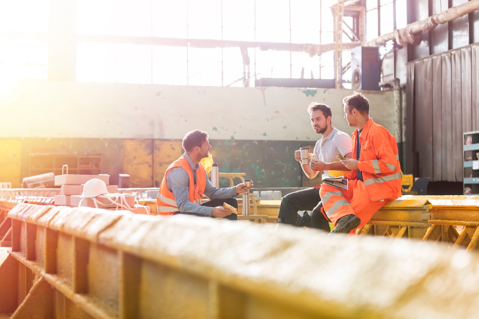 Three construction workers taking a tea break in the sunshine