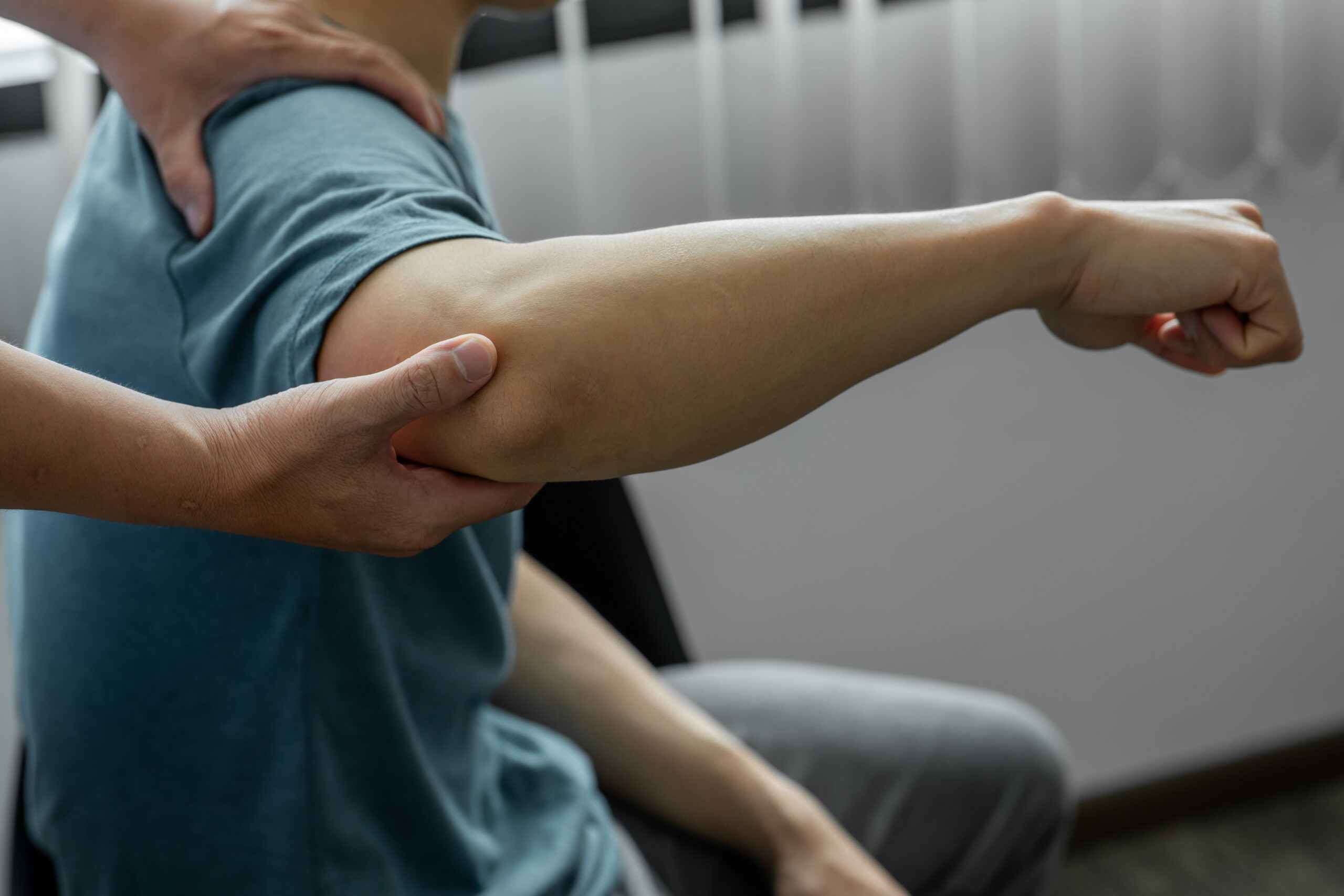 Onsite clinician examining the elbow of a worker