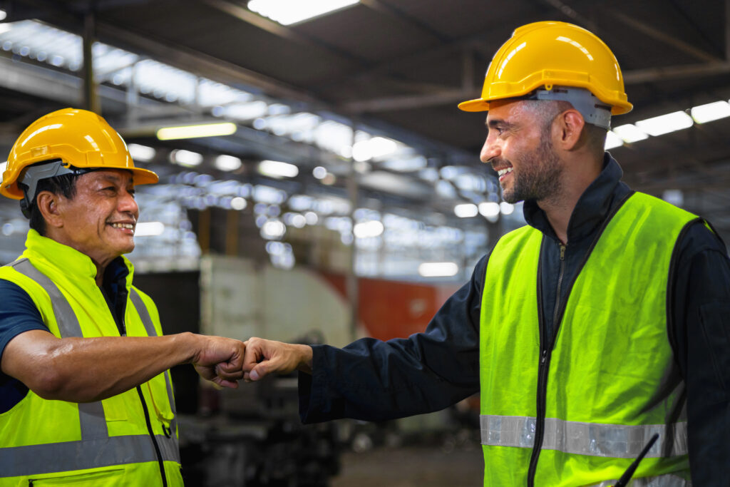 Supervisor greets worker with a fist bump, showing support and empathy.